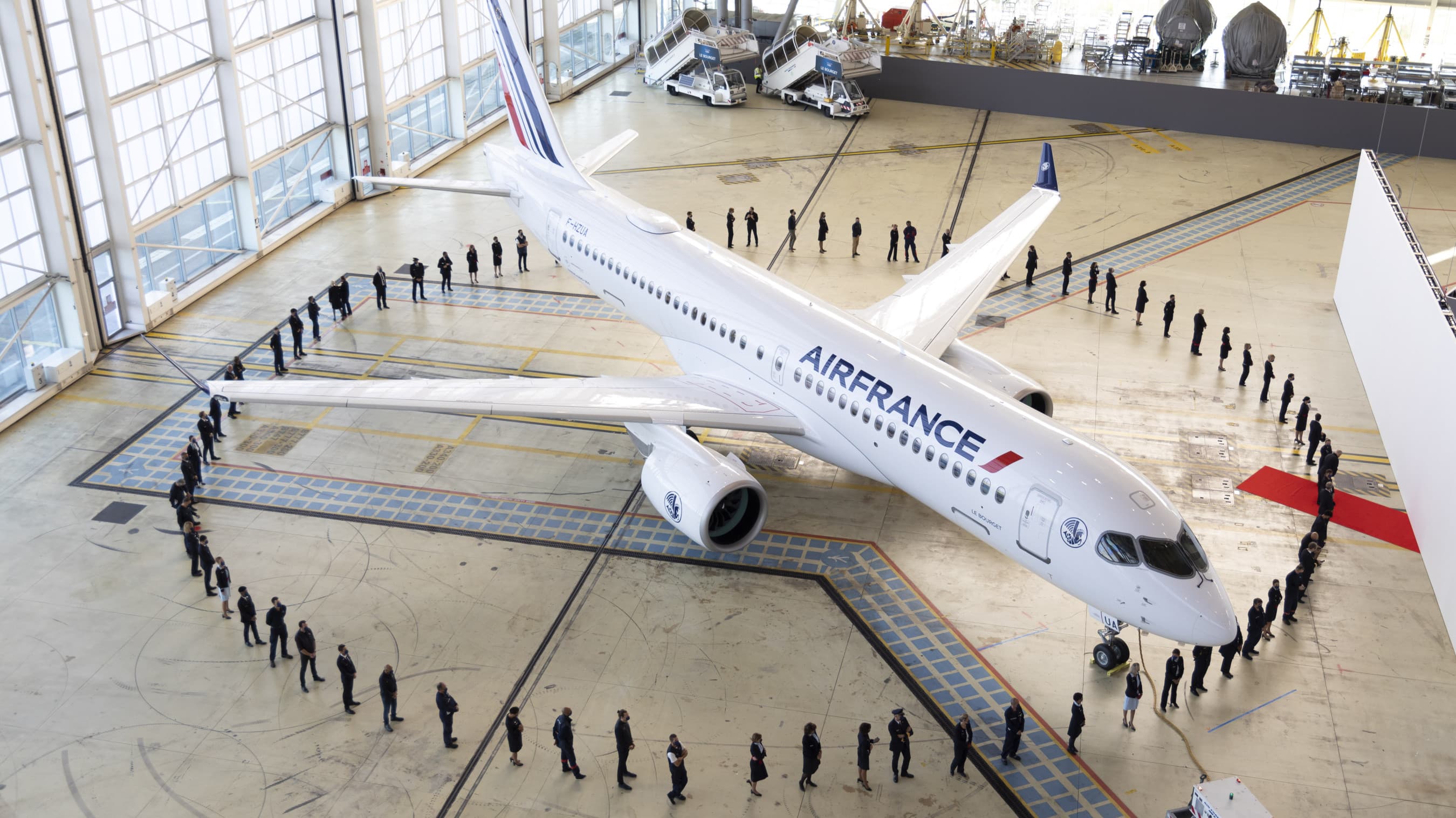 Photo avion dans hangar entouré par équipe Air France