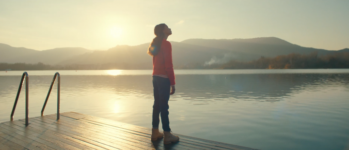 Une fille qui regarde le paysage devant un lac 