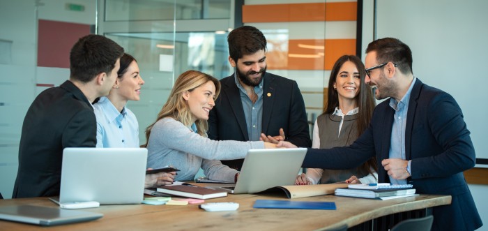 Friendly female leader boss shake hand of new staff member