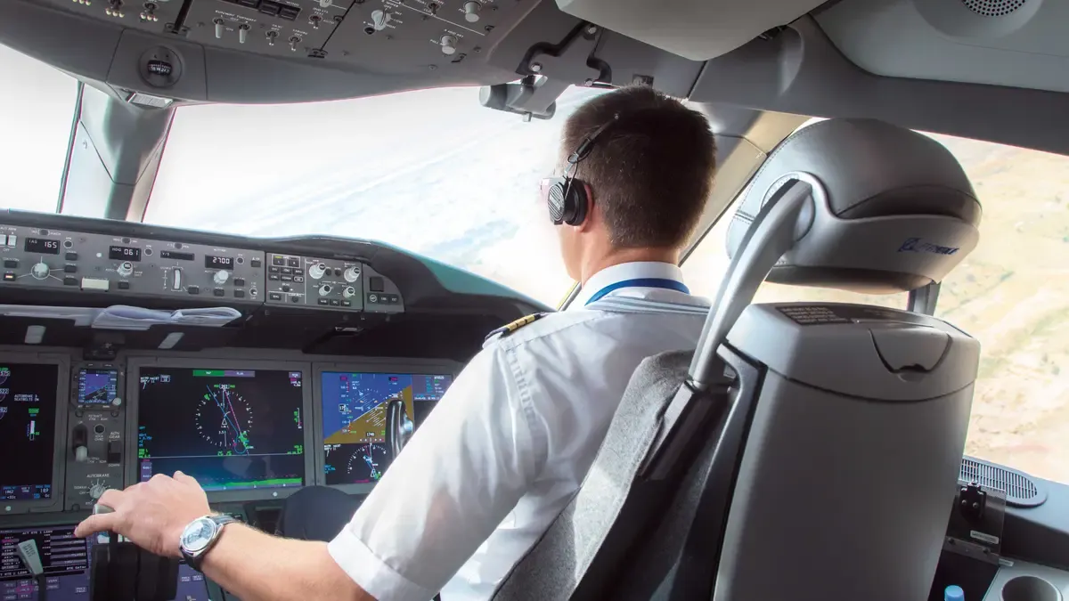 a pilote in the cockpit, captured from behind