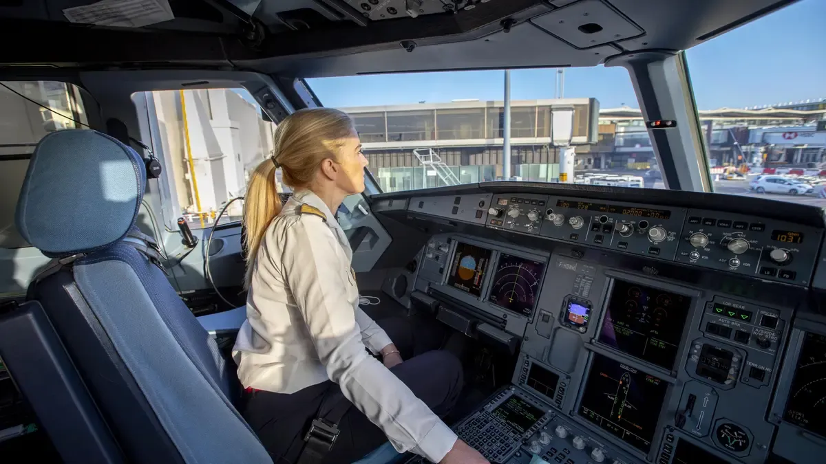 A blond woman pilot in the cockpit