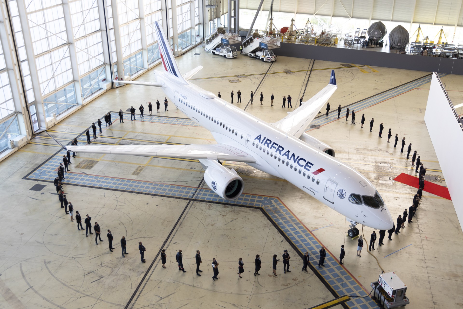 Photo avion dans hangar entouré par équipe Air France
