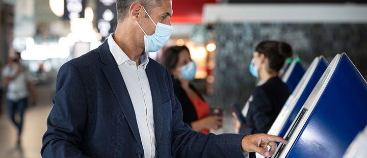 Homme qui se sert d'une borne a l'aéroport